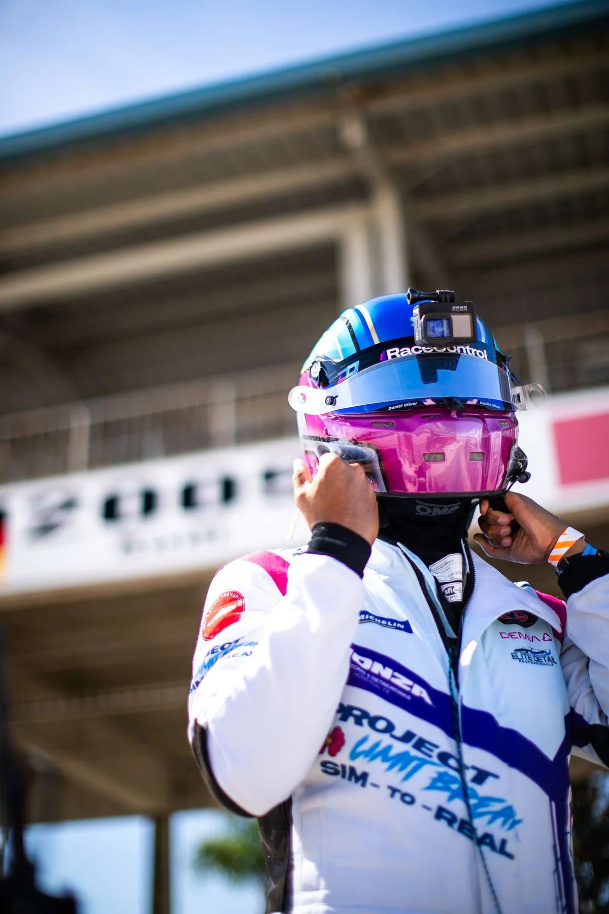 Daniel Oliver pulling on his helmet in front of the grandstand