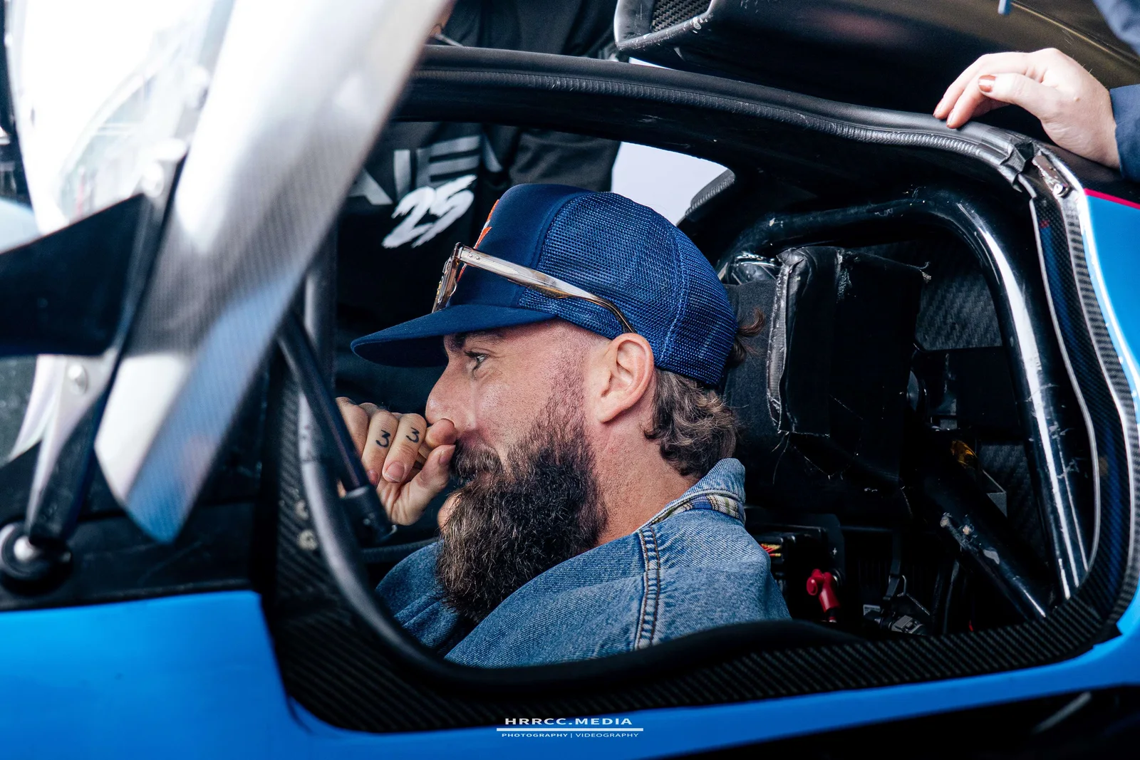 A sponsor guest sitting in the cockpit of the prototype, grinning